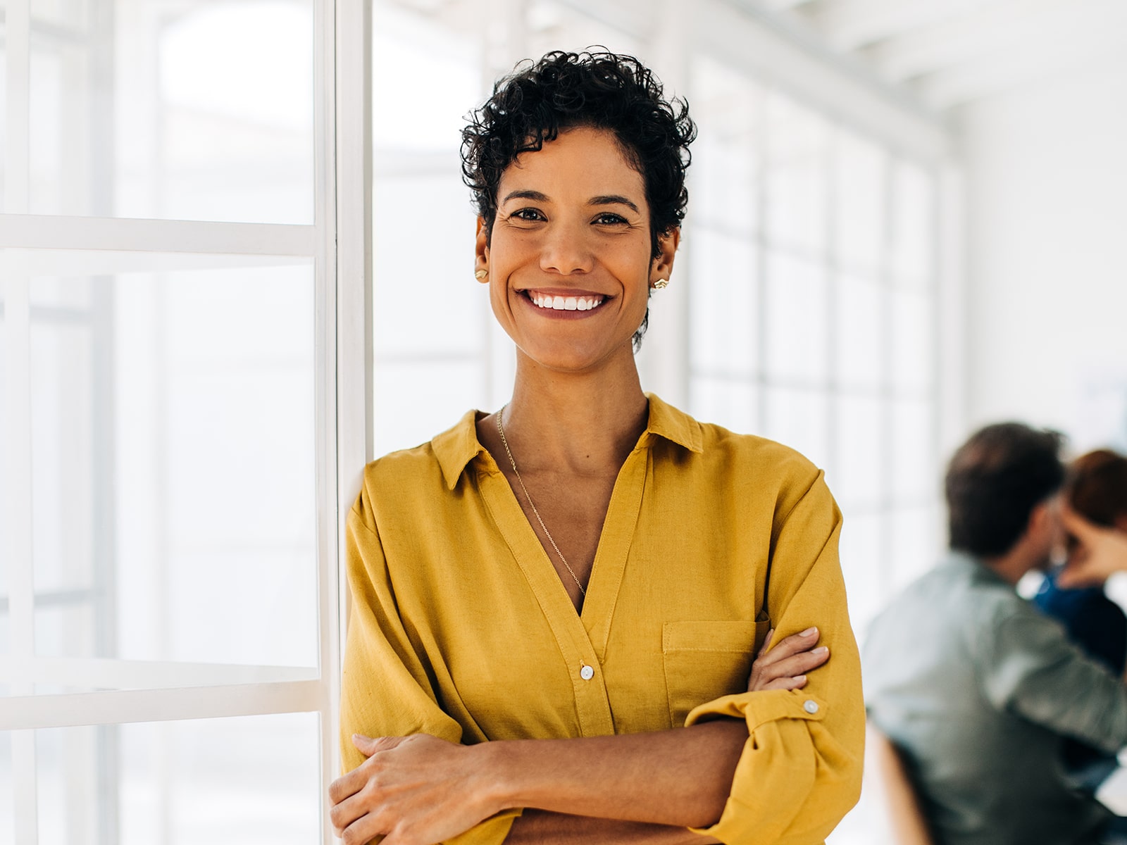 Woman in yellow blouse smiling in office setting